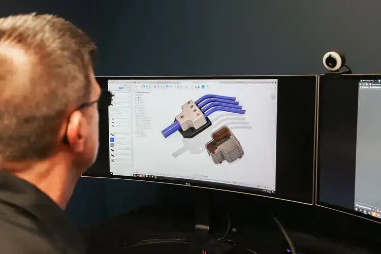 A guy working on a computer modeling parts in a 3d program