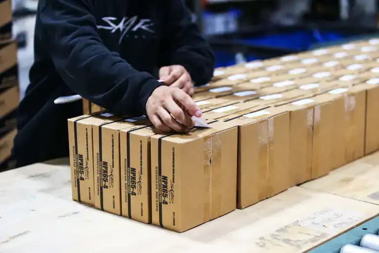 A guy placing a shipping label on a box